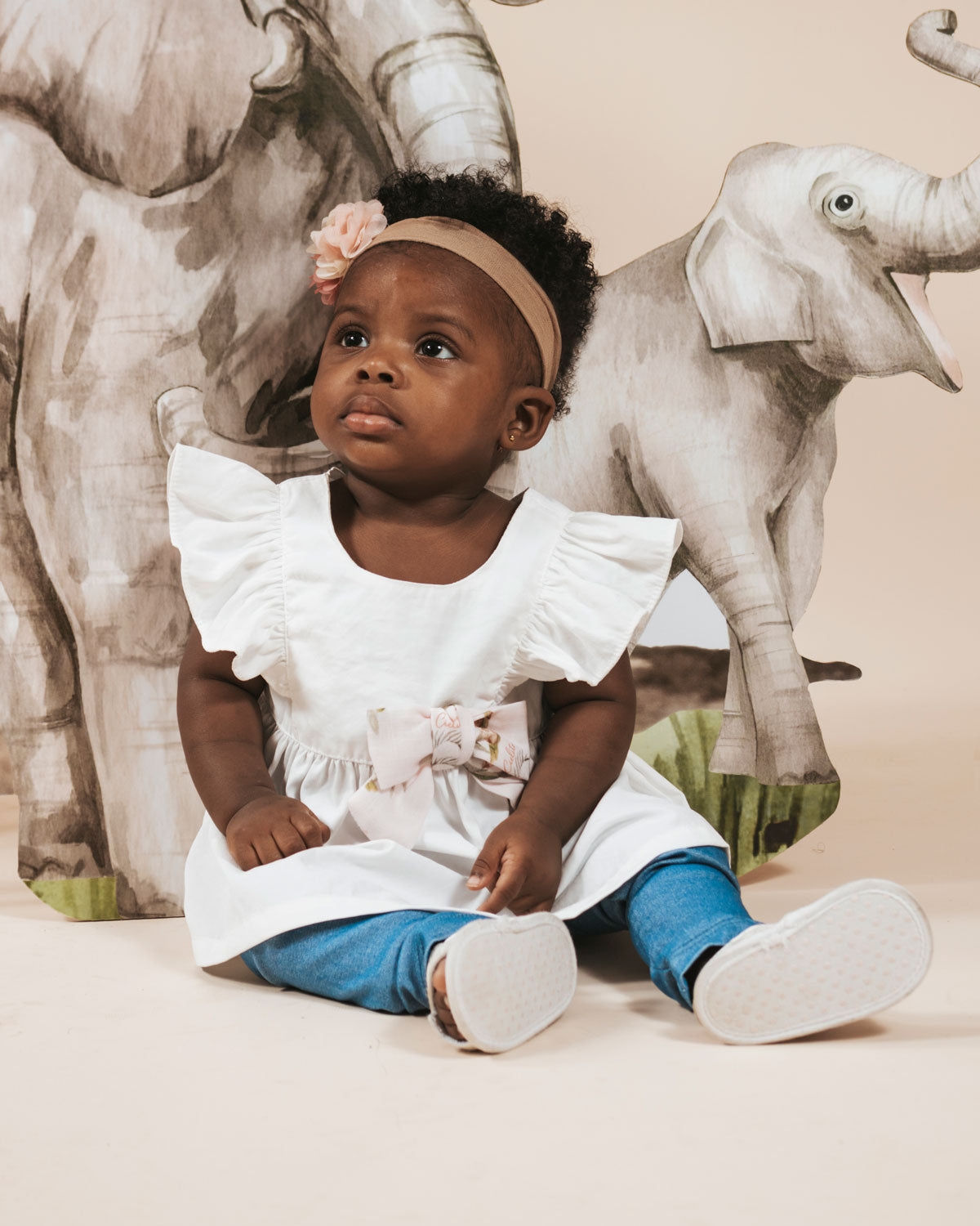 Conjunto blusa blanca con manga bolero, detalle de moño estampado y leggins azul para bebé niña