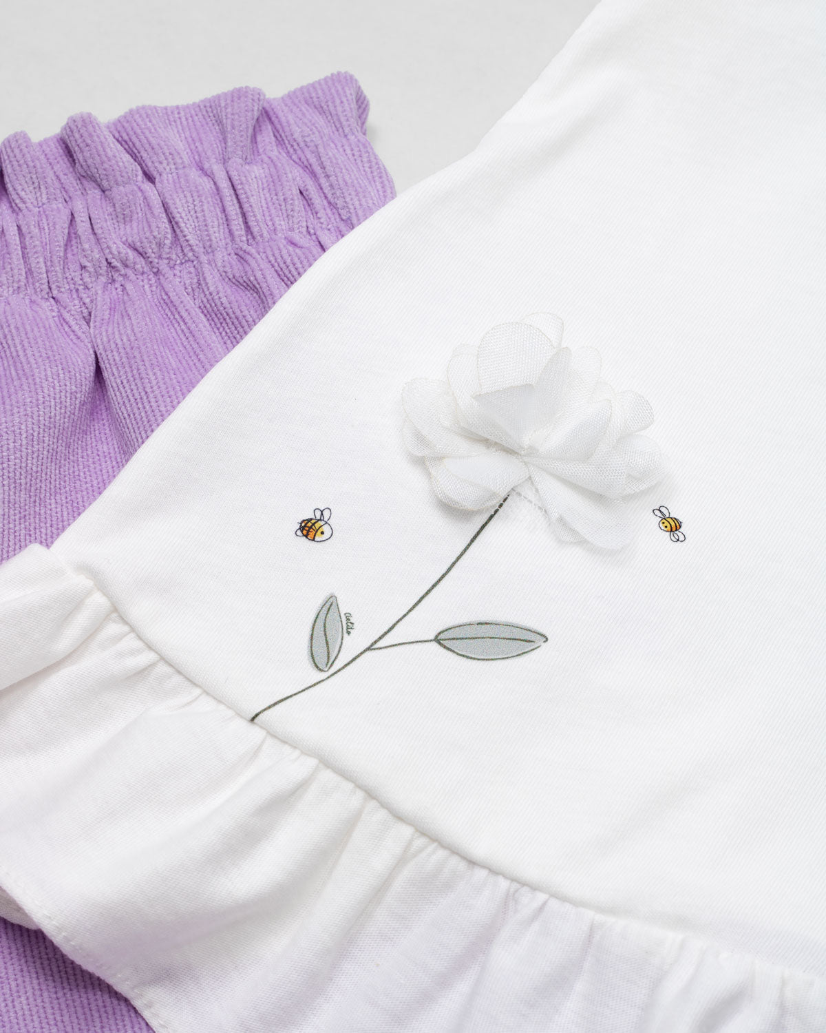 Conjunto blusa blanca sin mangas con aplique de flor y short lila para bebé niña