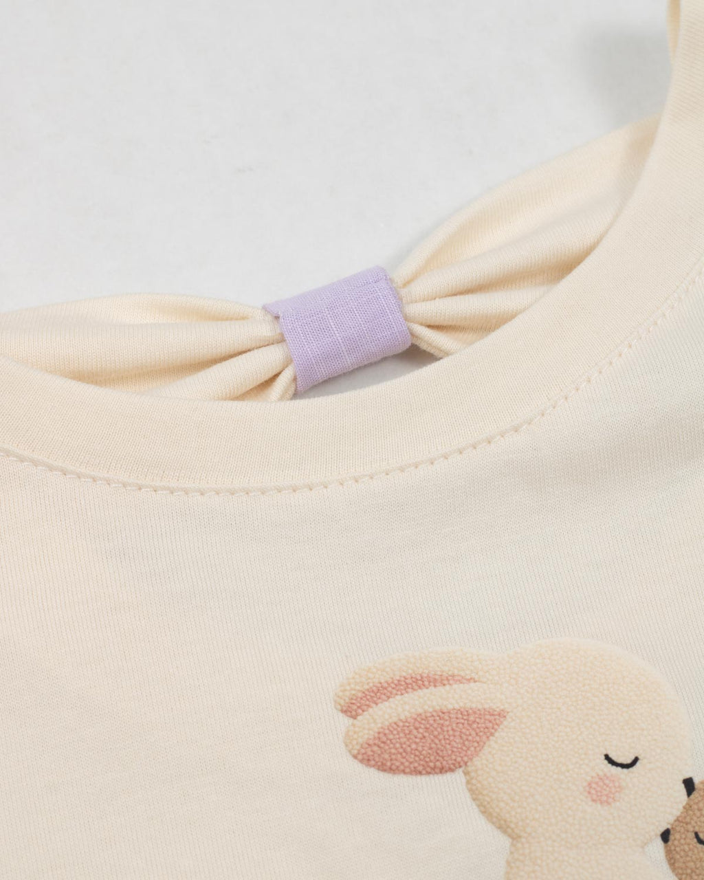 Conjunto blusa crema con estampado de conejitos y short lila para bebé niña