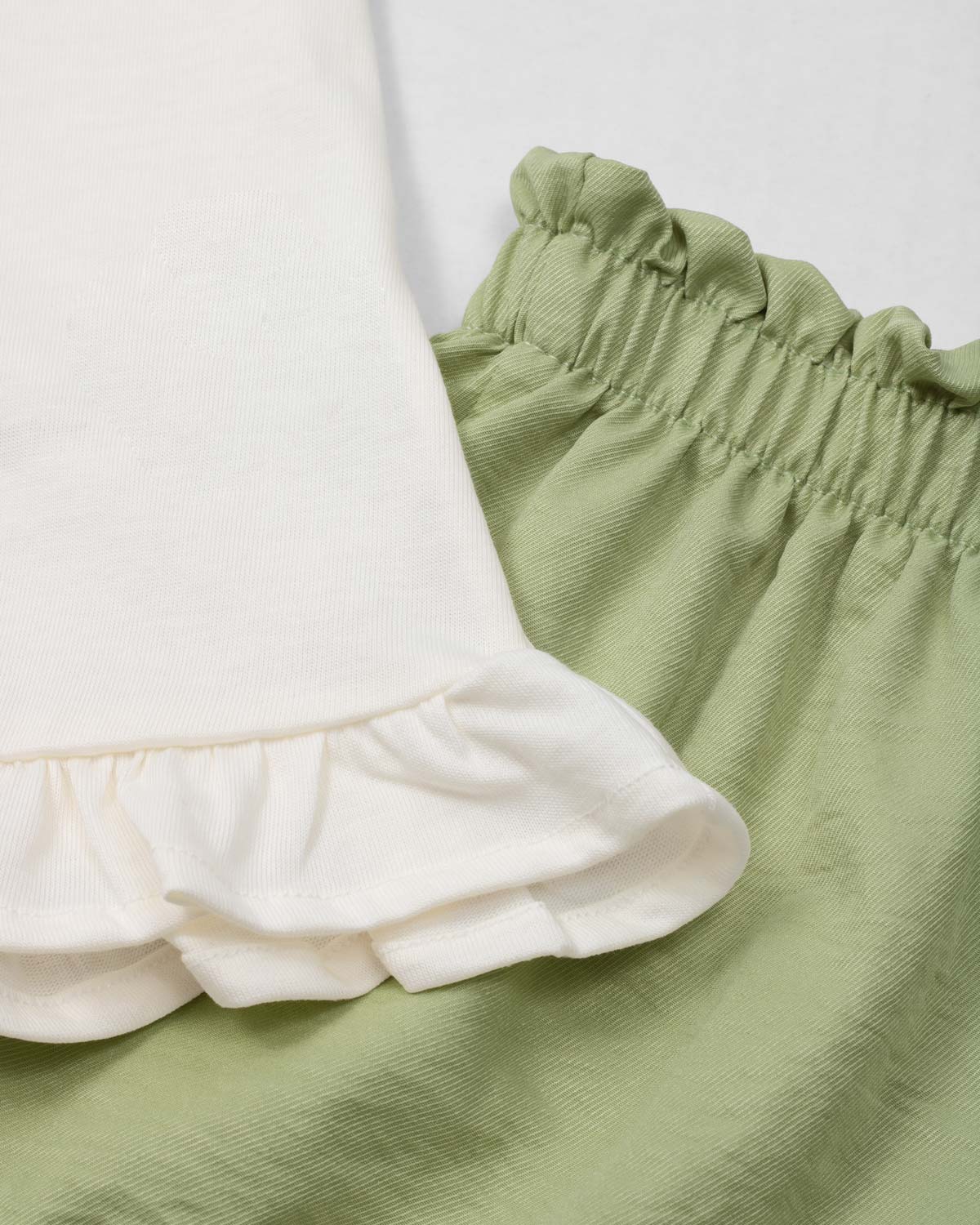 Conjunto blusa blanca con estampado, moño y short verde para niña