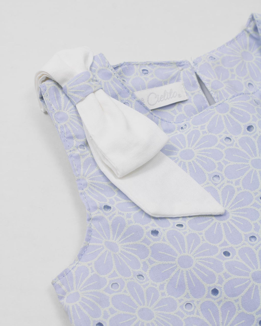 Conjunto blusa en tela hoja rota azul con moño y falda short blanca para bebé niña