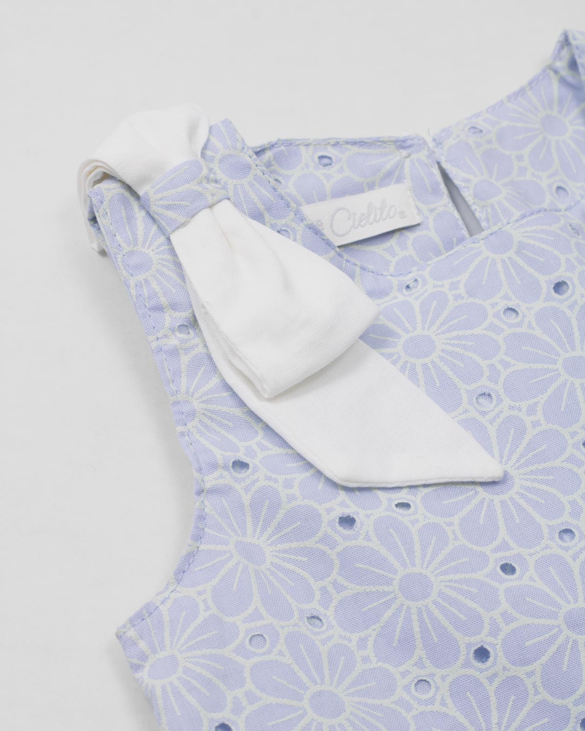 Conjunto blusa en tela hoja rota azul con moño y falda short blanca para bebé niña