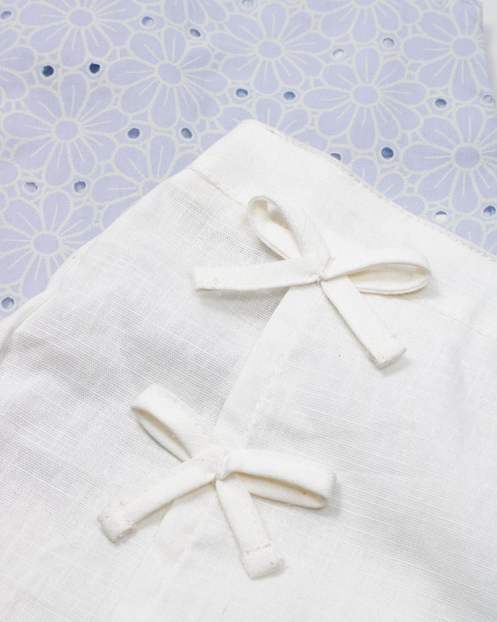Conjunto blusa en tela hoja rota azul con moño y falda short blanca para bebé niña