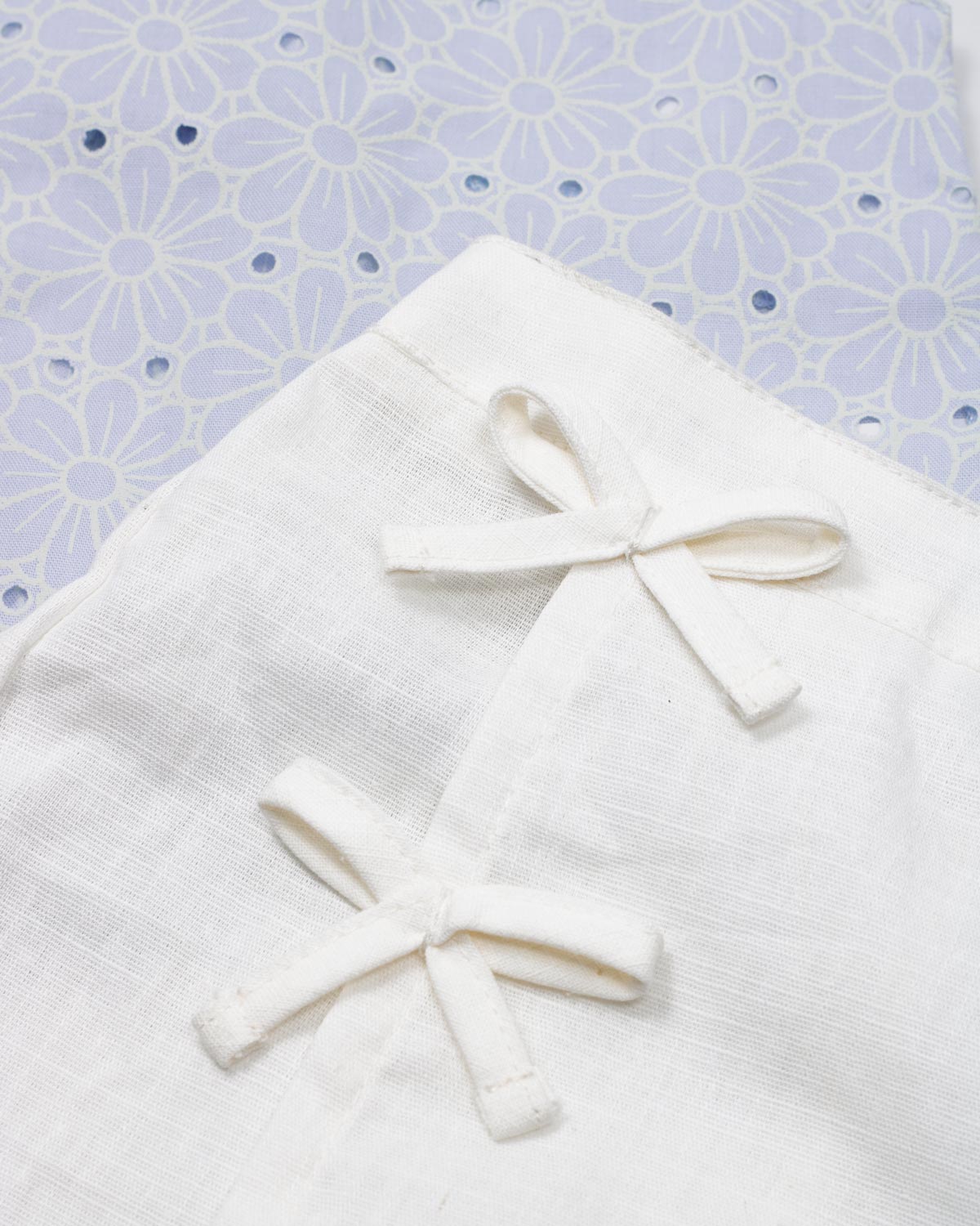 Conjunto blusa en tela hoja rota azul con moño y falda short blanca para bebé niña