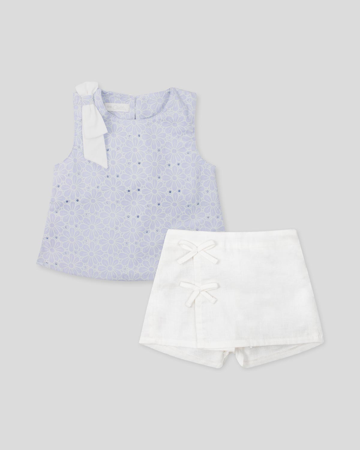 Conjunto blusa en tela hoja rota azul con moño y falda short blanca para bebé niña