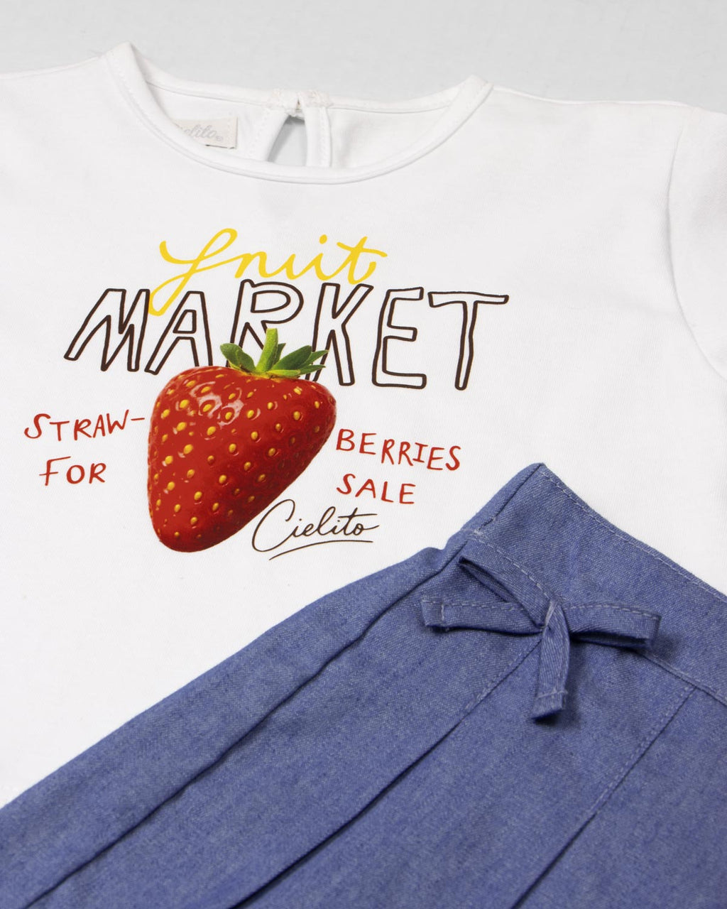 Conjunto blusa blanca estampada Fruit Market y falda short azul para bebé niña