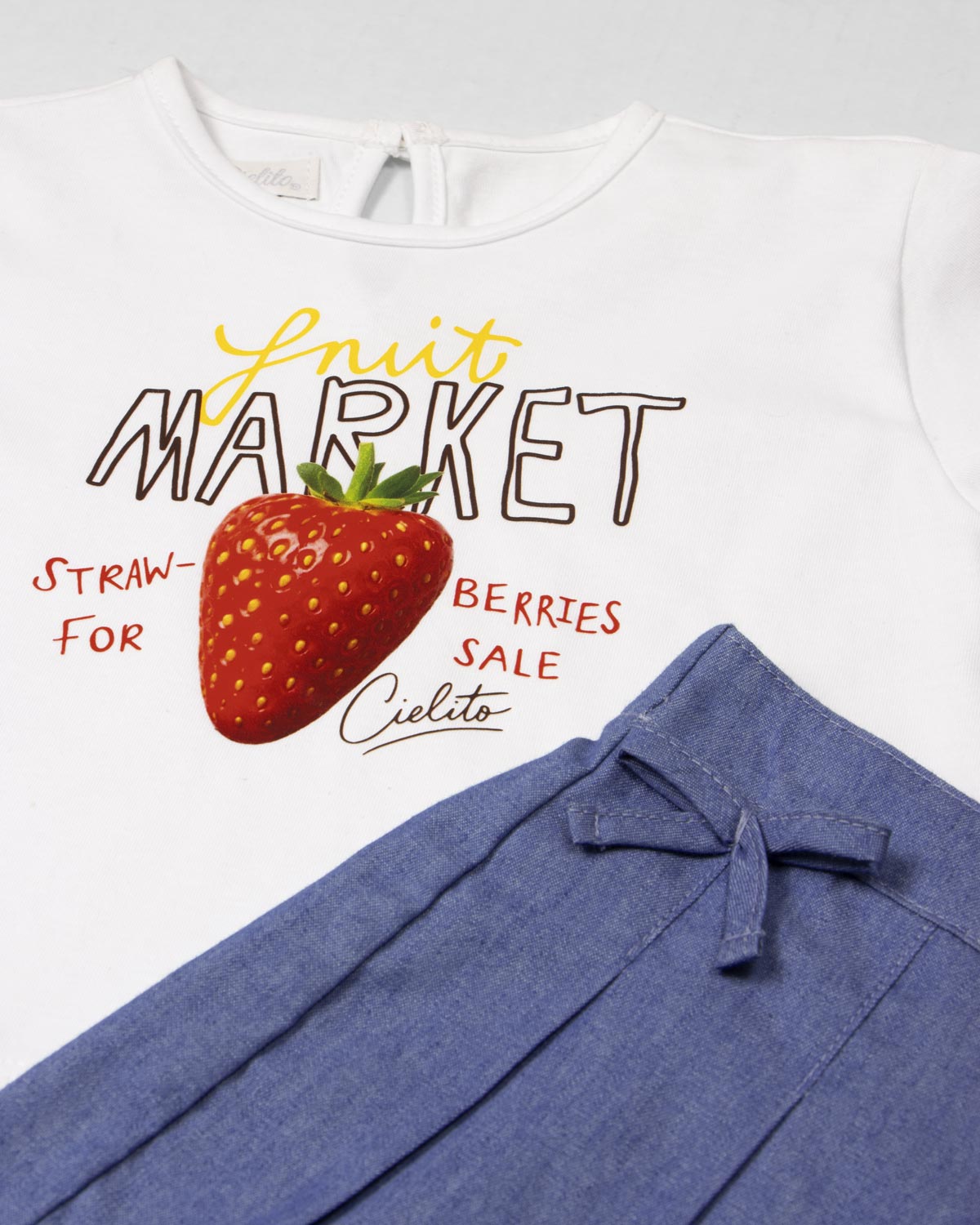 Conjunto blusa blanca estampada Fruit Market y falda short azul para bebé niña