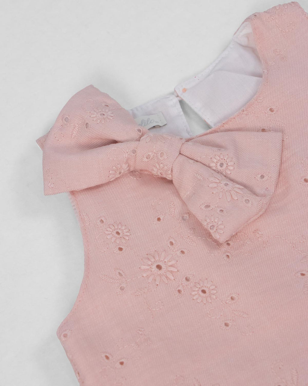 Conjunto blusa rosa con moño en tela hoja rota y falda short blanca para bebé niña