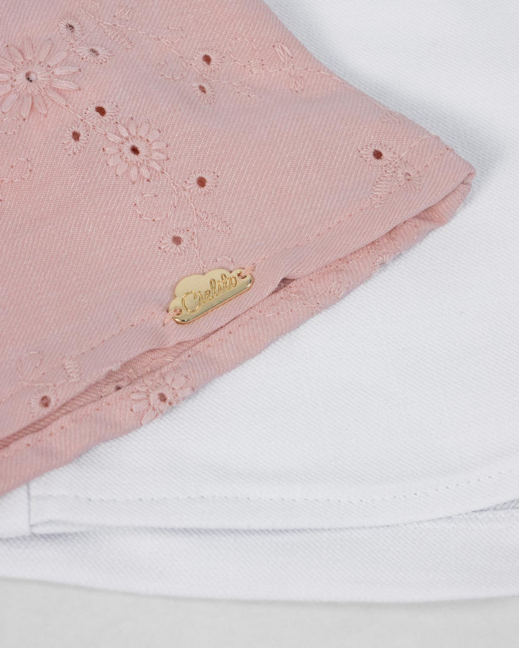 Conjunto blusa rosa con moño en tela hoja rota y falda short blanca para bebé niña
