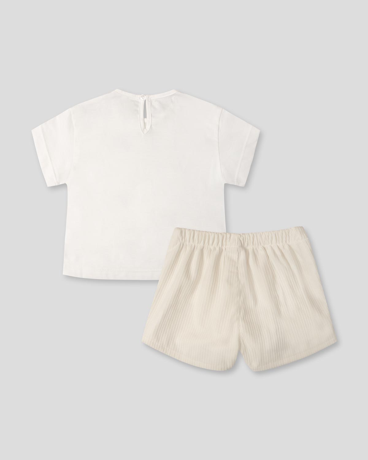 Conjunto camiseta blanca con moños negros y falda short crema para bebé niña