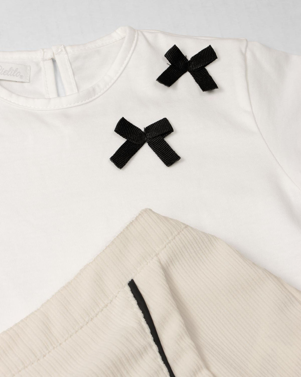 Conjunto camiseta blanca con moños negros y falda short crema para bebé niña
