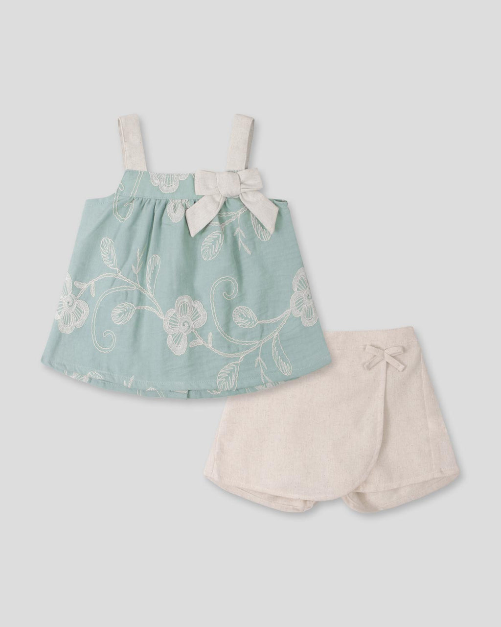 Conjunto blusa verde menta en tela bordada con moño y falda short beige para bebé niña