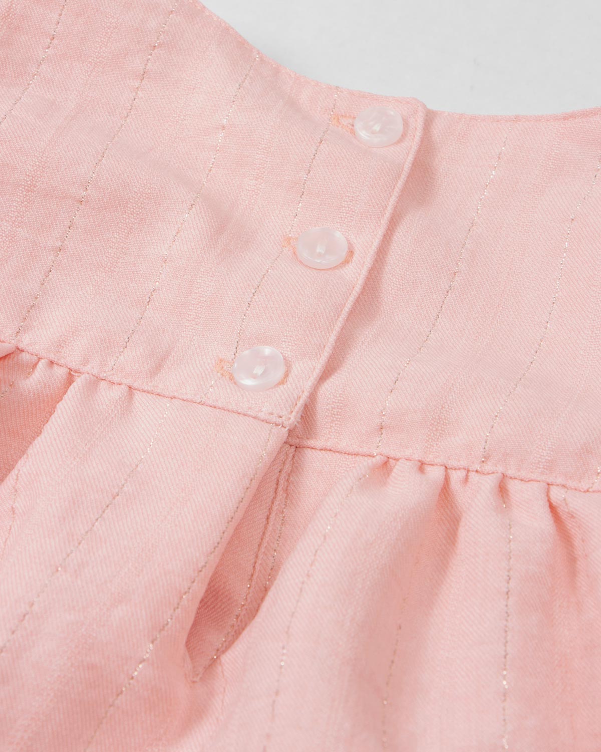 Vestido body rosa con detalle de líneas plateadas y moño en hombro para bebé niña