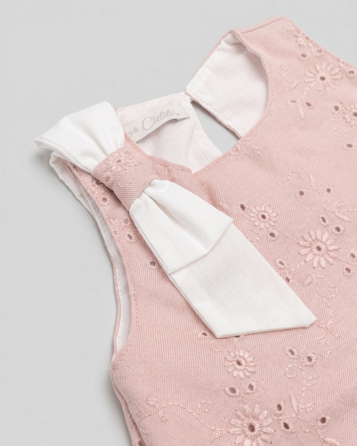 Vestido rosa en tela hoja rota con moño blanco en hombro para bebé niña
