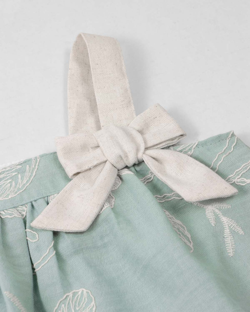 Vestido verde menta de tiras en tela bordada con moño para bebé niña