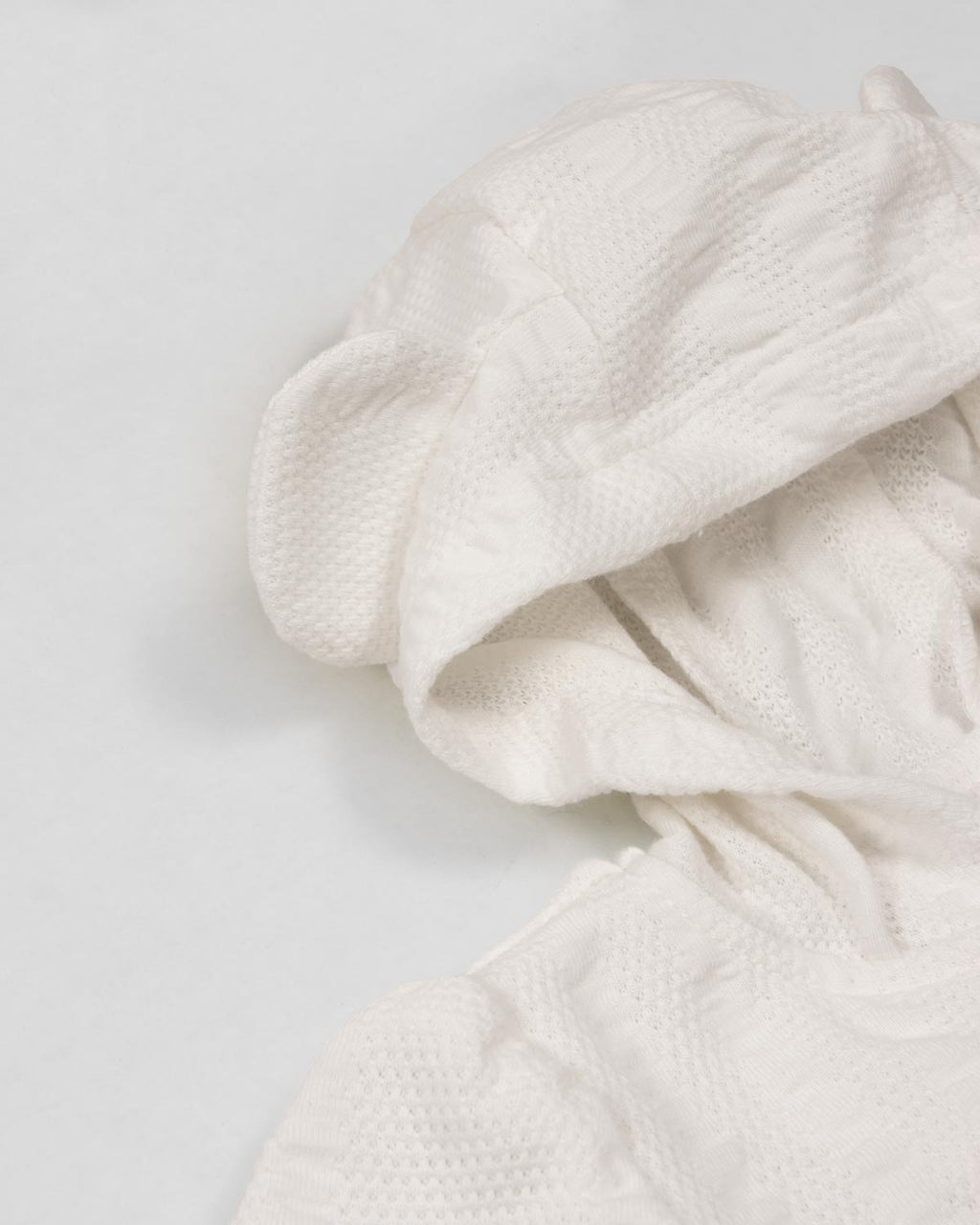 Pijama blanca de dos piezas con gorrito para recién nacida