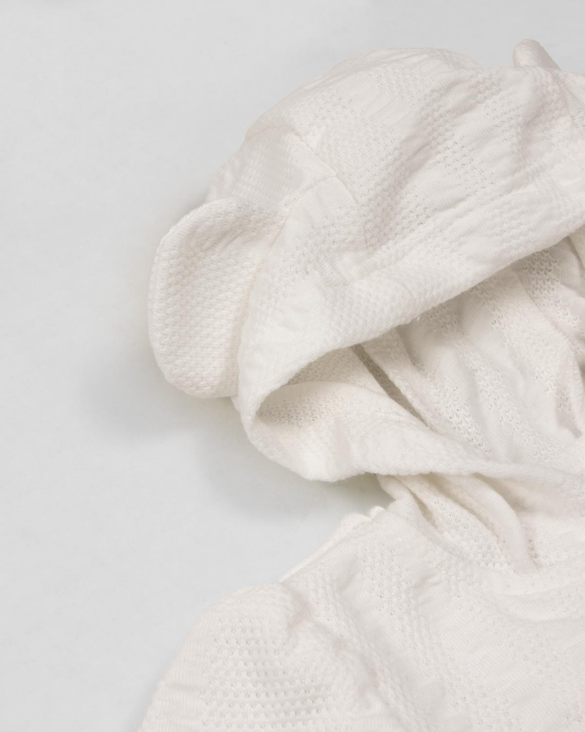 Pijama blanca de dos piezas con gorrito para recién nacida