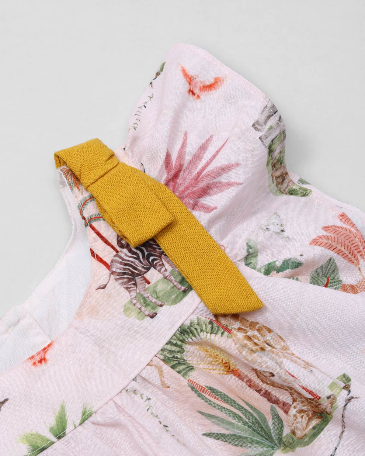 Conjunto blusa estampada con detalle de moños en hombros y short mostaza para niña