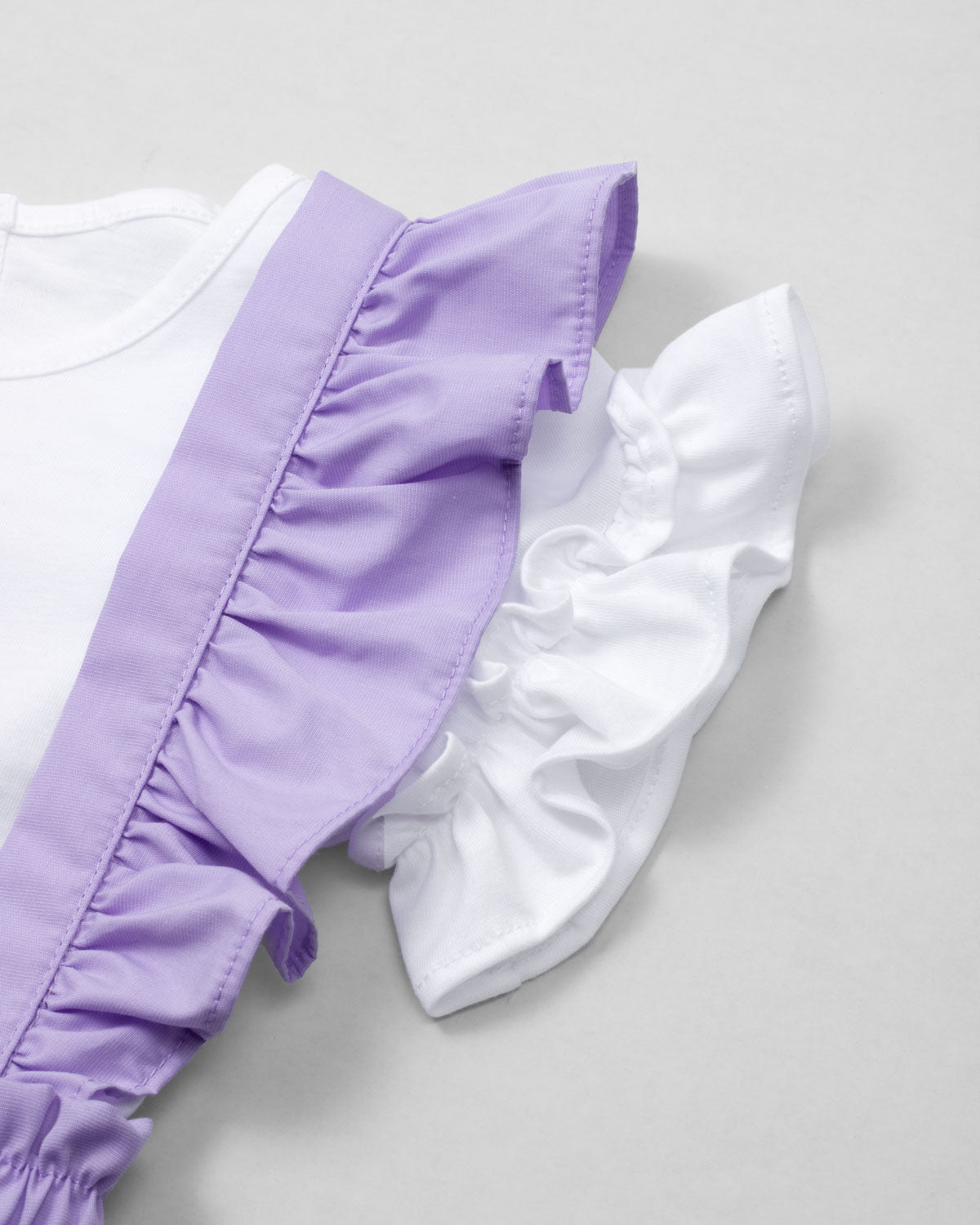 Conjunto blusa blanca con bordado, mangas con boleros y short lila con tirantes para niña