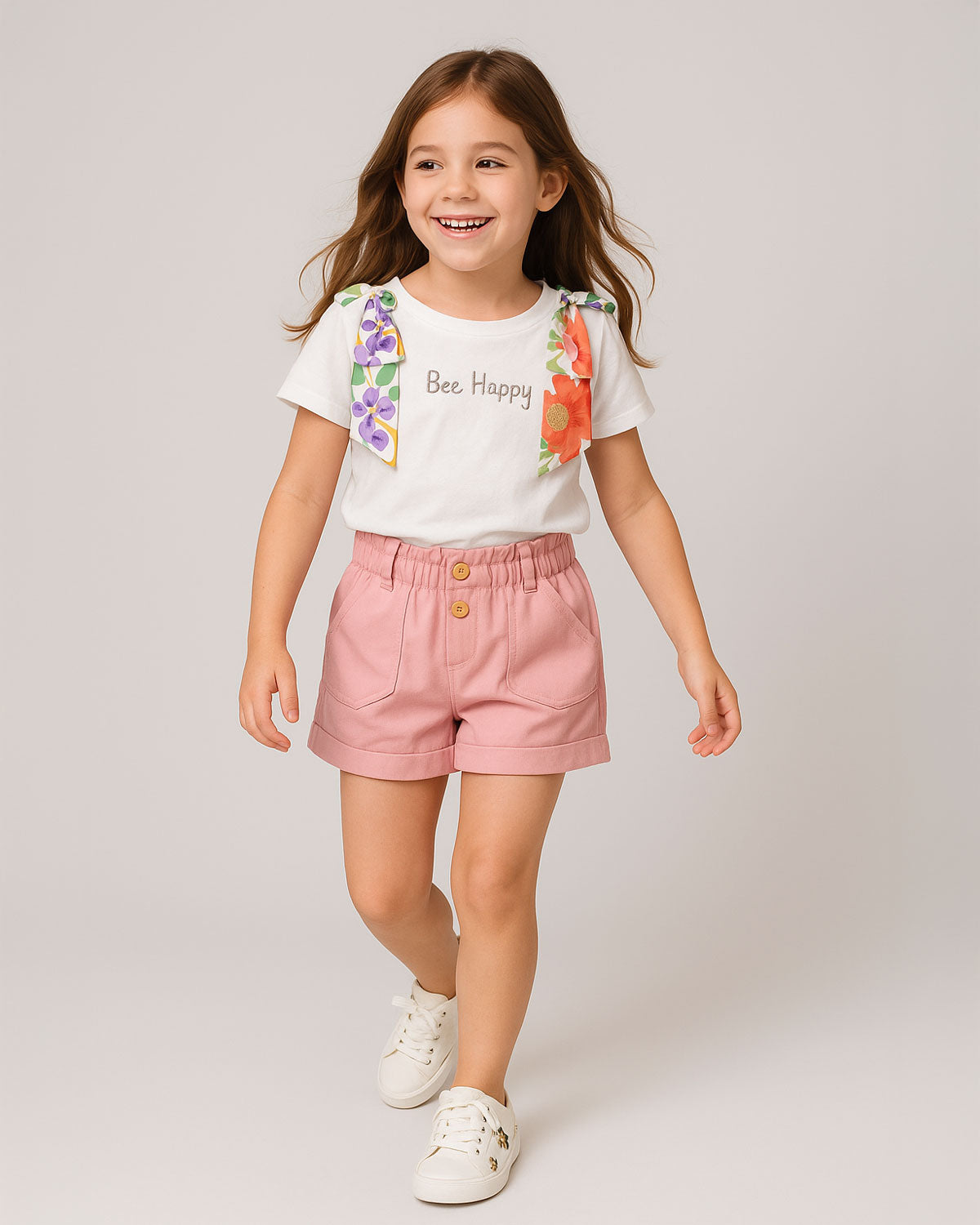 Conjunto blusa blanca con moños estampados en hombro y short rosa con bolsillos para niña