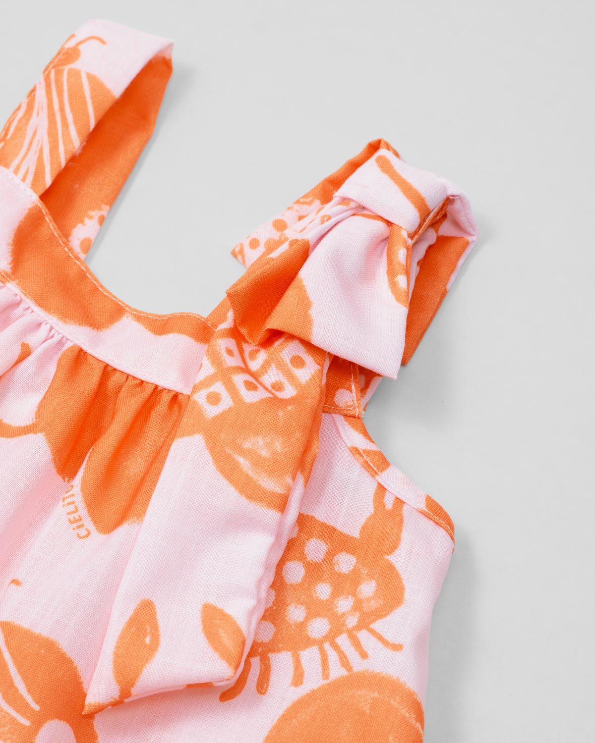 Conjunto blusa estampada de tiras con detalle de moño y short beige para niña