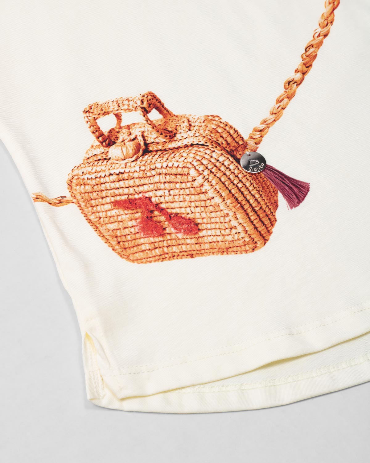 Conjunto blusa vainilla con estampado de bolso y falda rosa para niña