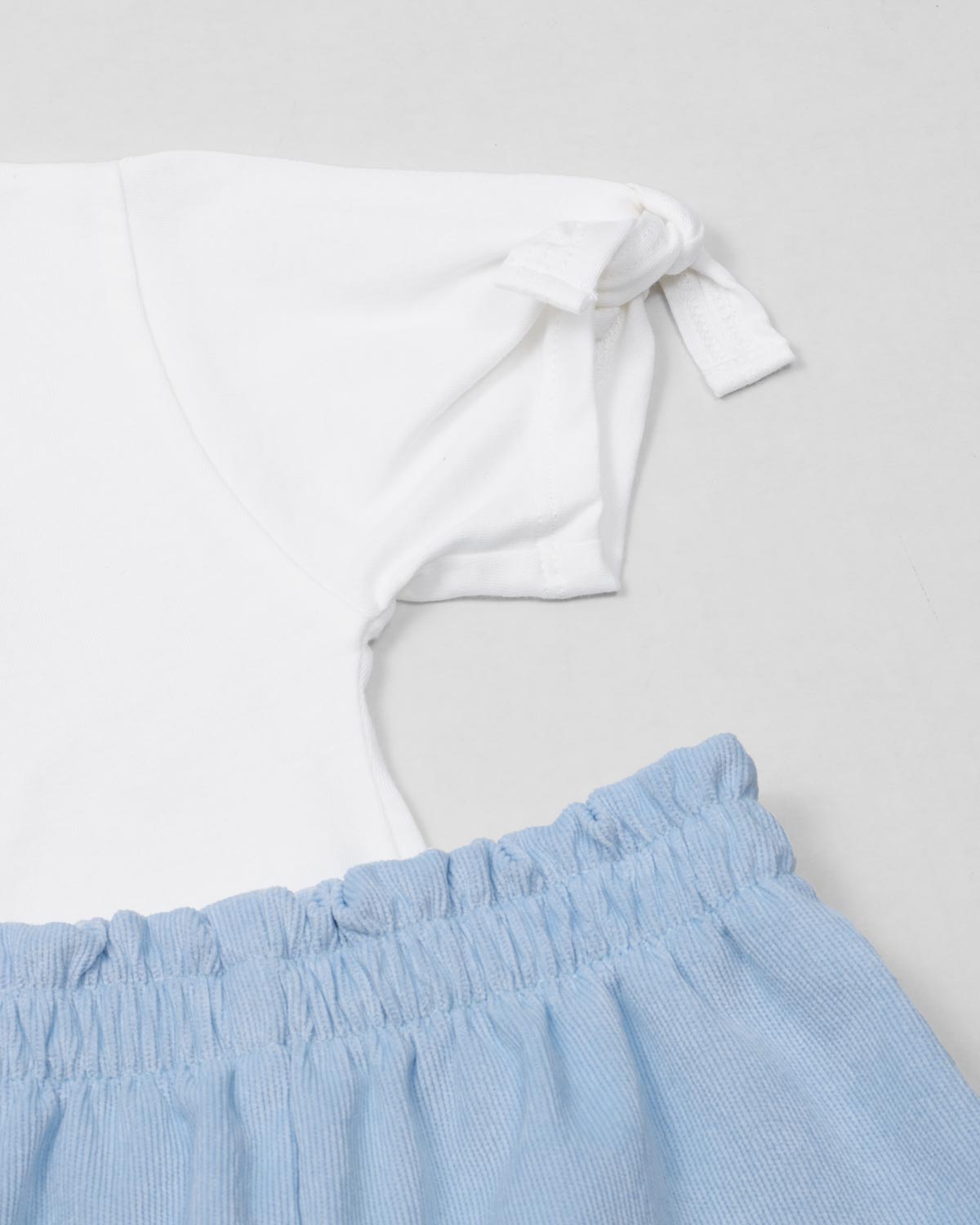 Camiseta blanca con estampado de perritos y short azul con bolsillos para niña