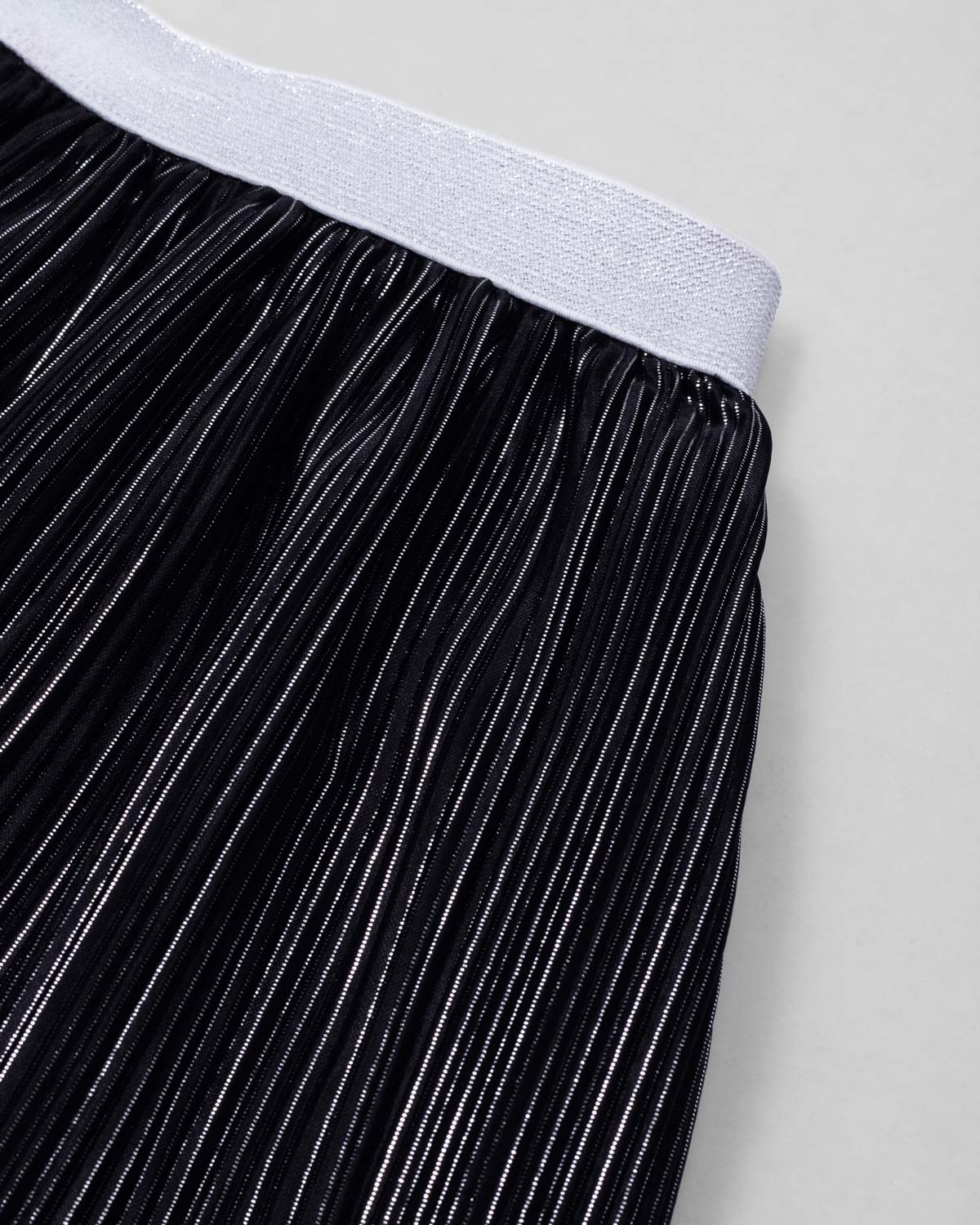 Conjunto blusa blanca con moño y falda negra plisada brillante para niña