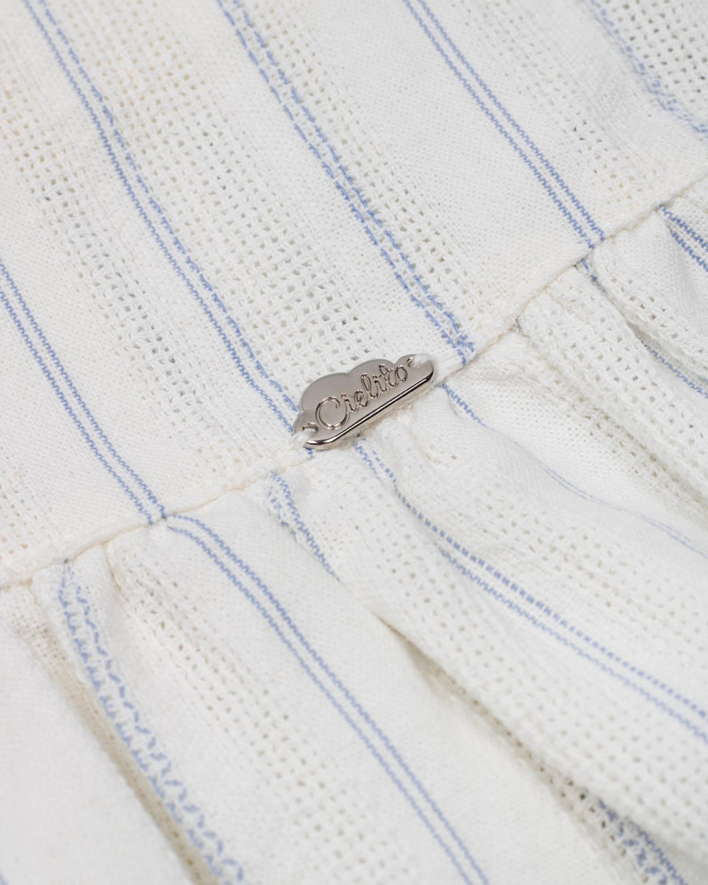 Conjunto blusa blanca con moñitos azules y falda short con prenses azul para niña