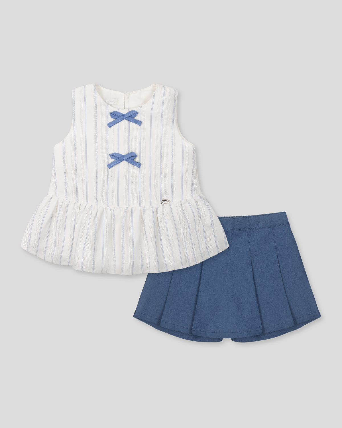 Conjunto blusa blanca con moñitos azules y falda short con prenses azul para niña