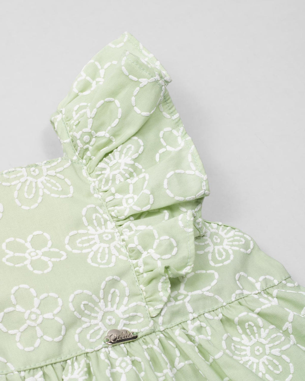 Conjunto blusa verde estampada con moño y short blanco para niña