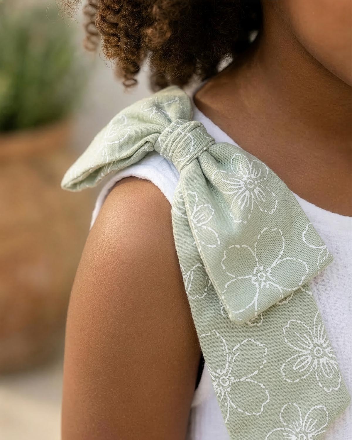 Conjunto blusa blanca con botones, moño y falda short verde estampado para niña