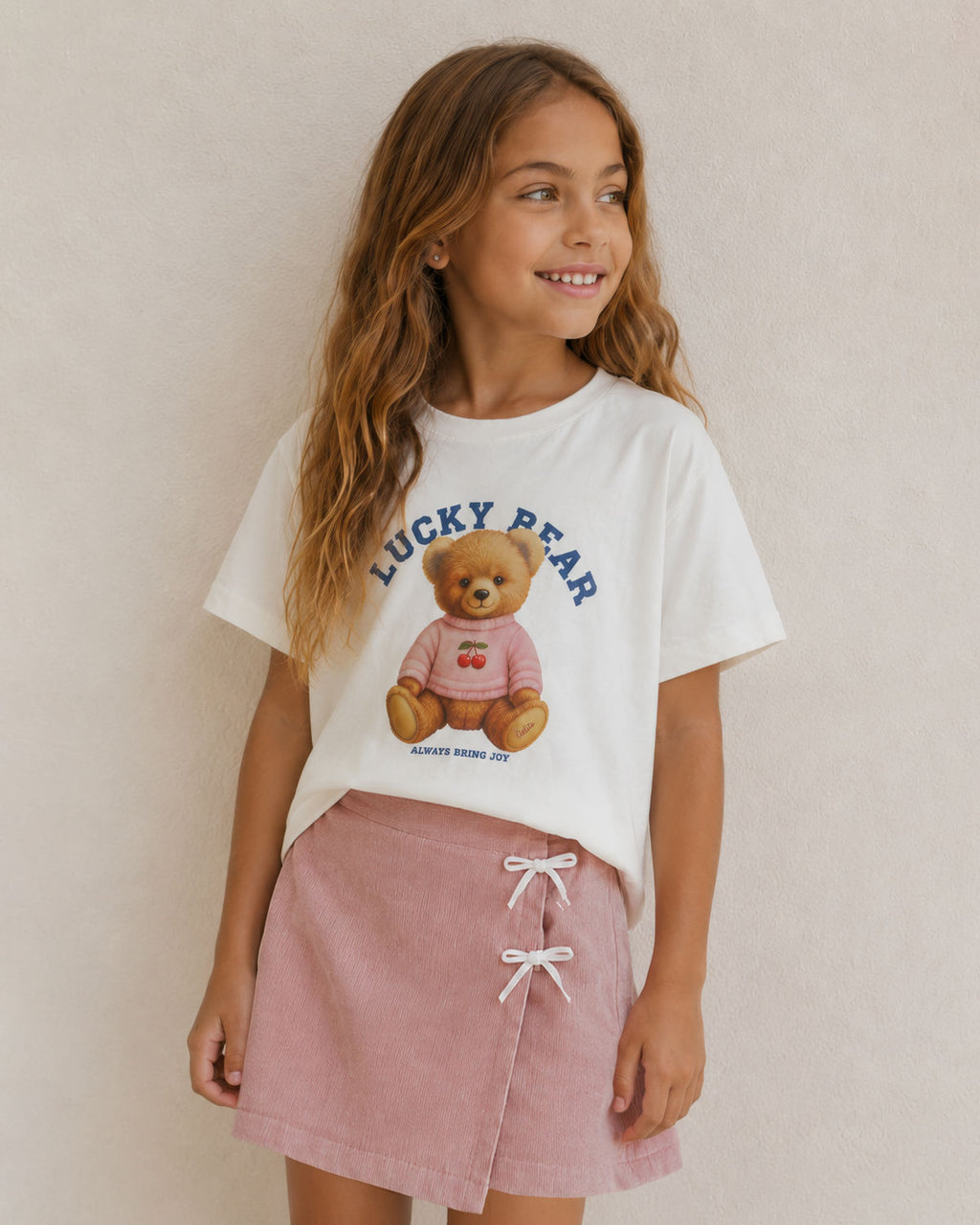Conjunto blusa blanca con estampado de osita y falda short rosa con moñitos para niña