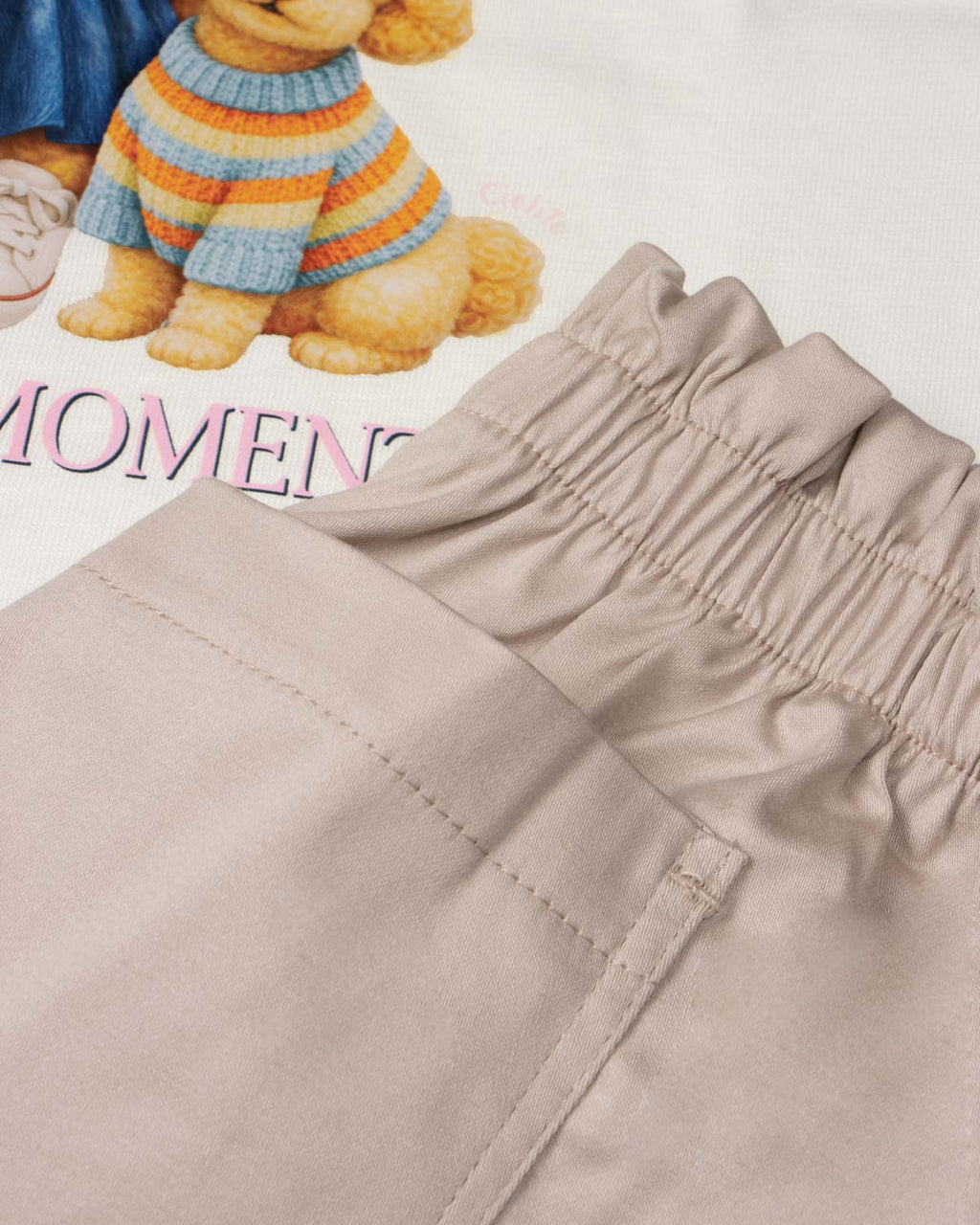 Conjunto blusa blanca estampada con moñitos y short beige para niña