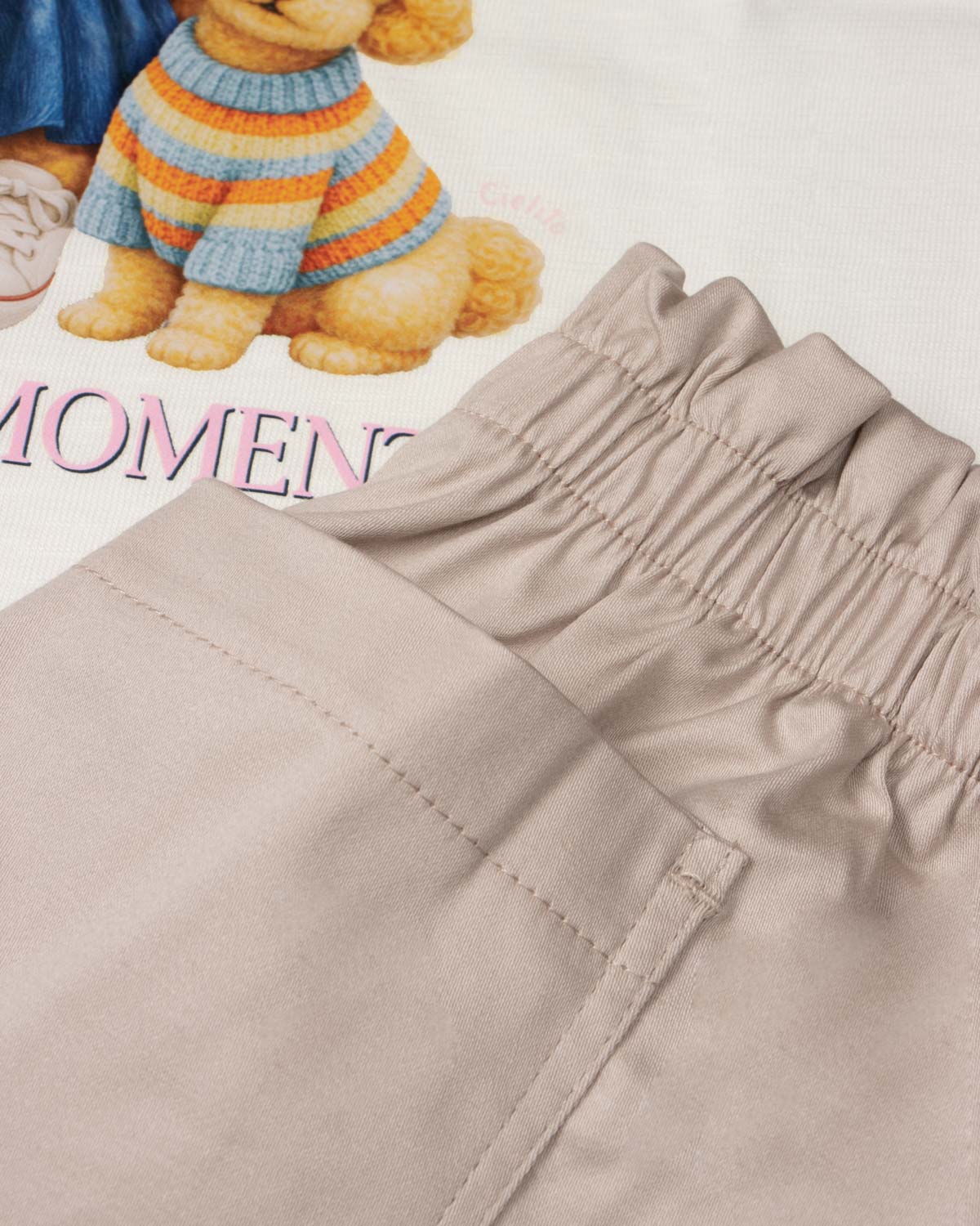 Conjunto blusa blanca estampada con moñitos y short beige para niña