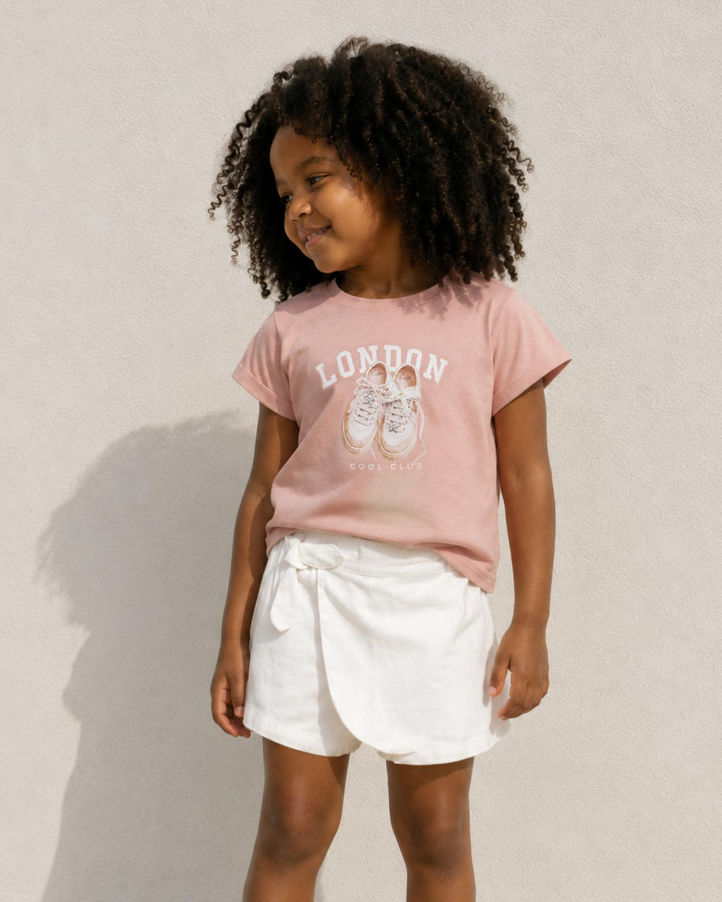 Conjunto camisa rosa estampada y falda short blanca para niña