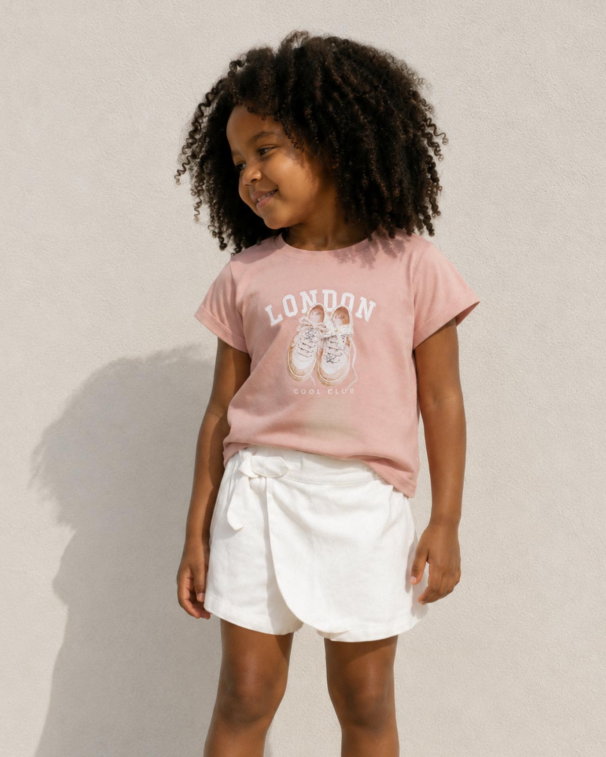 Conjunto camisa rosa estampada y falda short blanca para niña