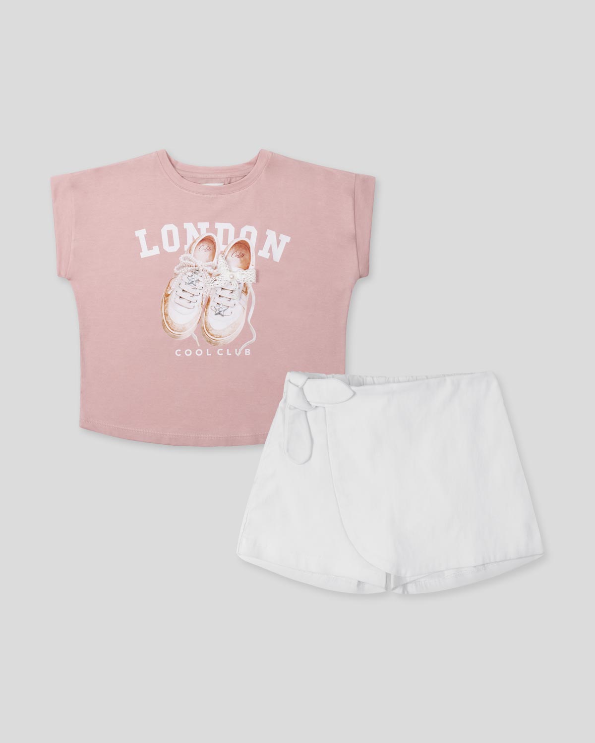 Conjunto camisa rosa estampada y falda short blanca para niña