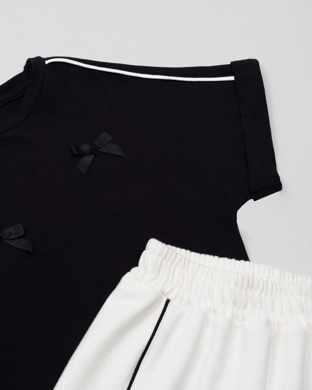 Conjunto blusa negra con moñitos y pantalón blanco para niña