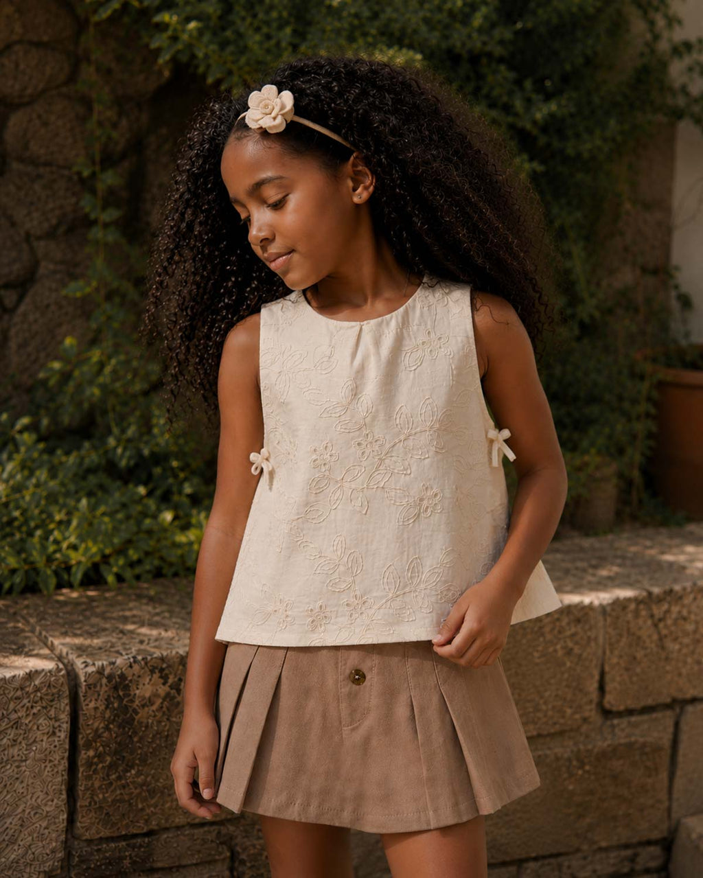 Conjunto blusa en tela hoja rota crema con moñitos y falda short café para niña
