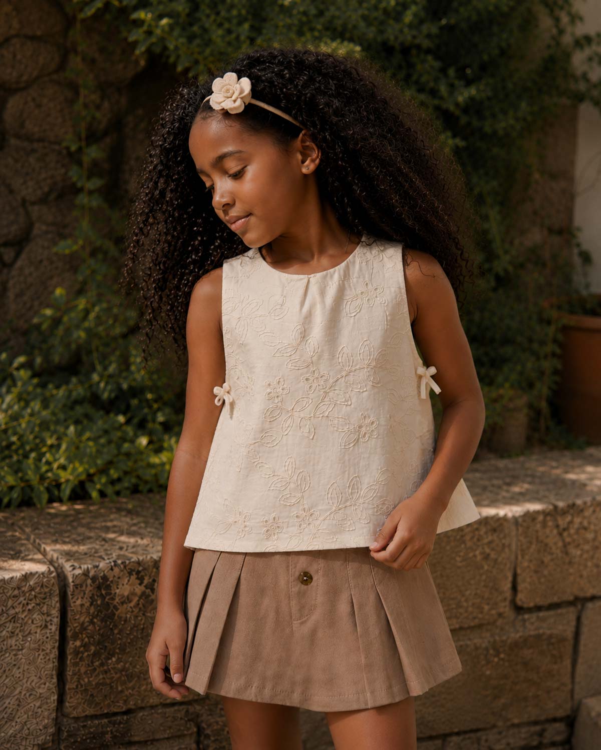 Conjunto blusa en tela hoja rota crema con moñitos y falda short café para niña