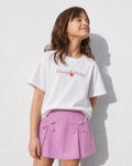 Conjunto camiseta blanca estampada y falda short lila con moños para niña