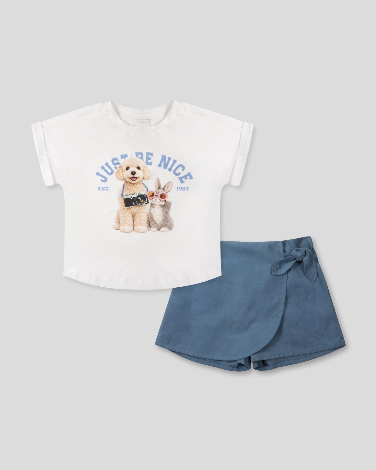 Conjunto camiseta blanca con estampado ''Just Be Nice'' y falda short azul para niña