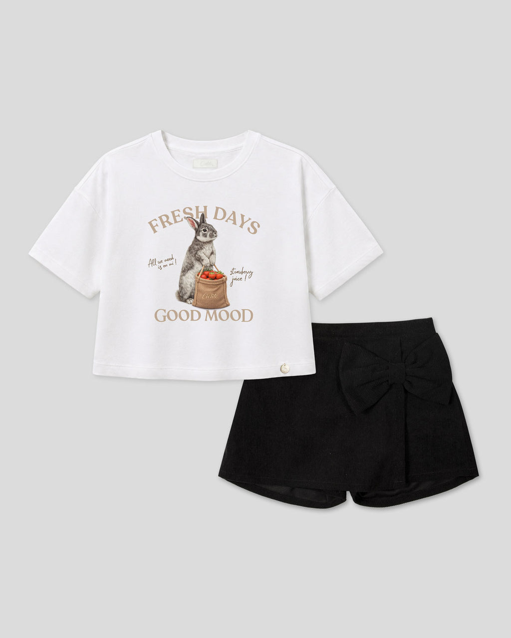 Conjunto blusa blanca con estampado de conejito y falda short negra con moño para niña