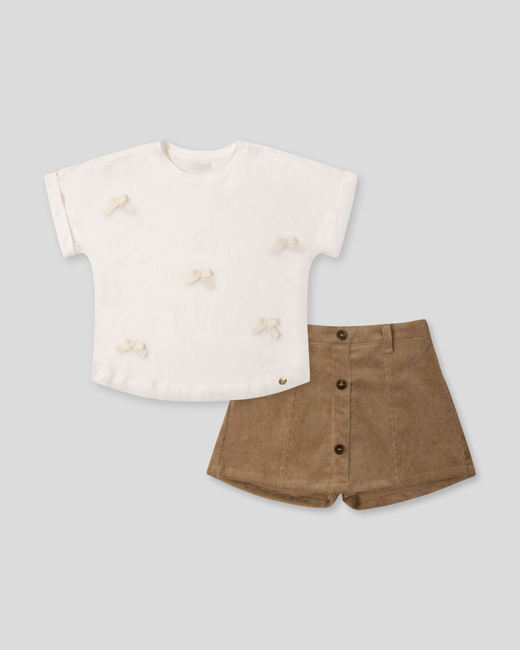 Conjunto camiseta blanca con moños y falda short café para niña