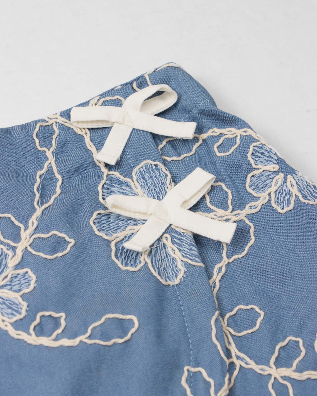 Conjunto blusa blanca y falda short azul con bordado de flores para niña