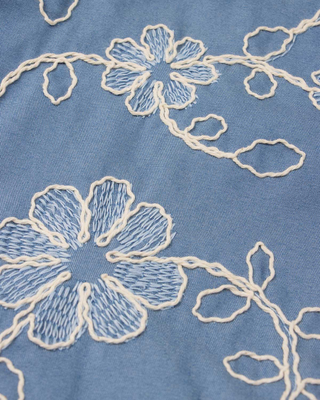 Conjunto blusa blanca y falda short azul con bordado de flores para niña