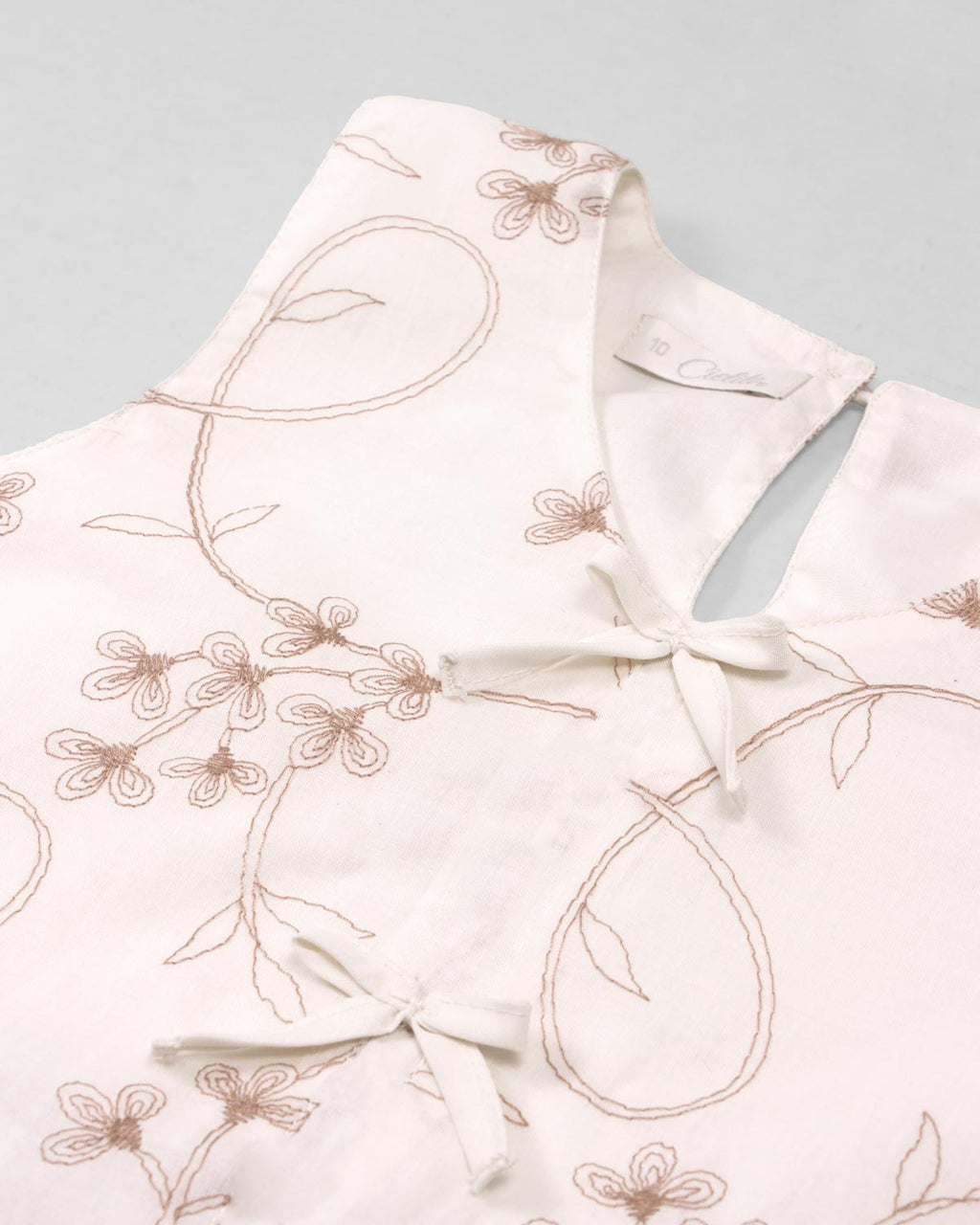 Conjunto blusa blanca con bordados de flores y falda short rosa con pliegues para niña