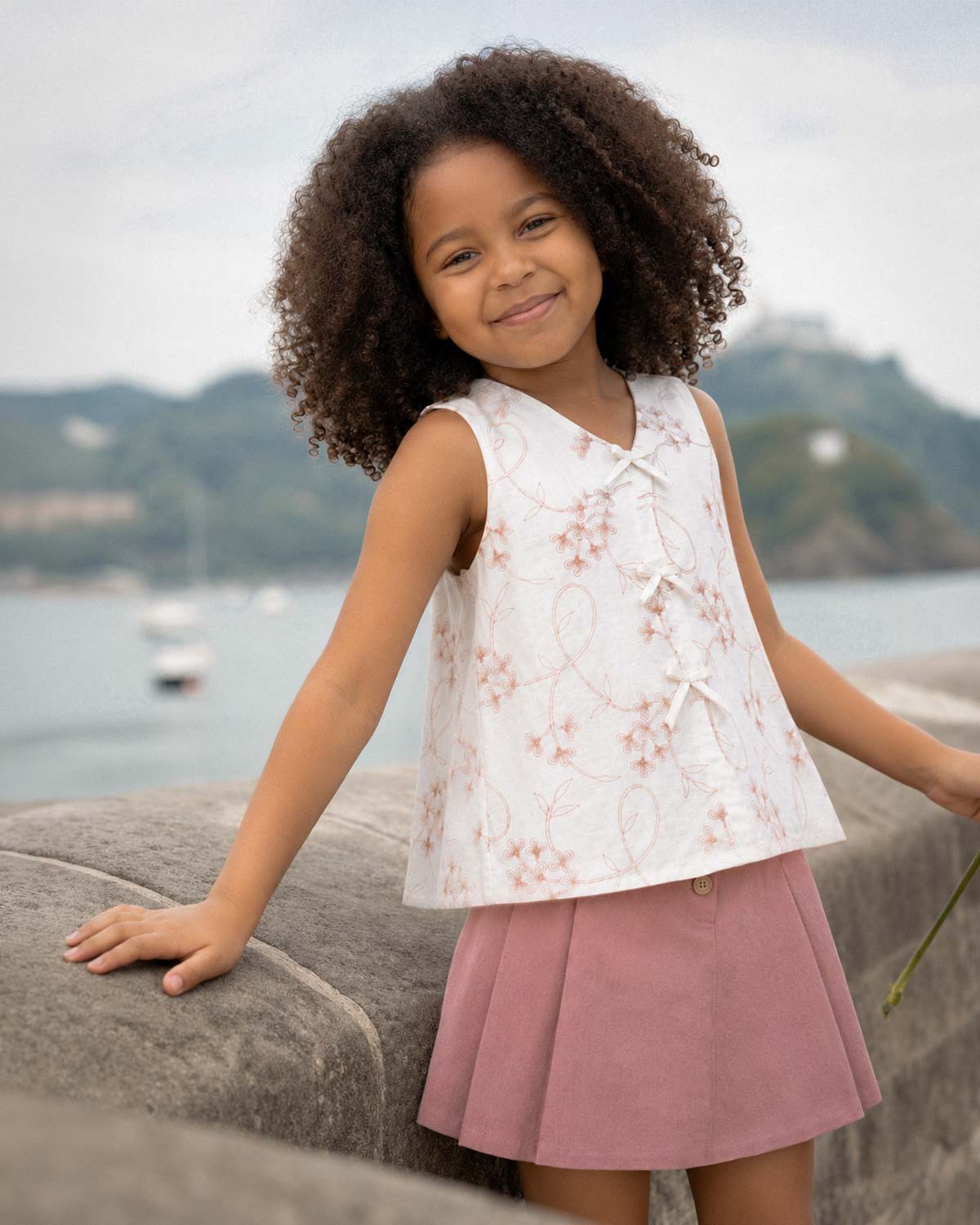 Conjunto blusa blanca con bordados de flores y falda short rosa con pliegues para niña