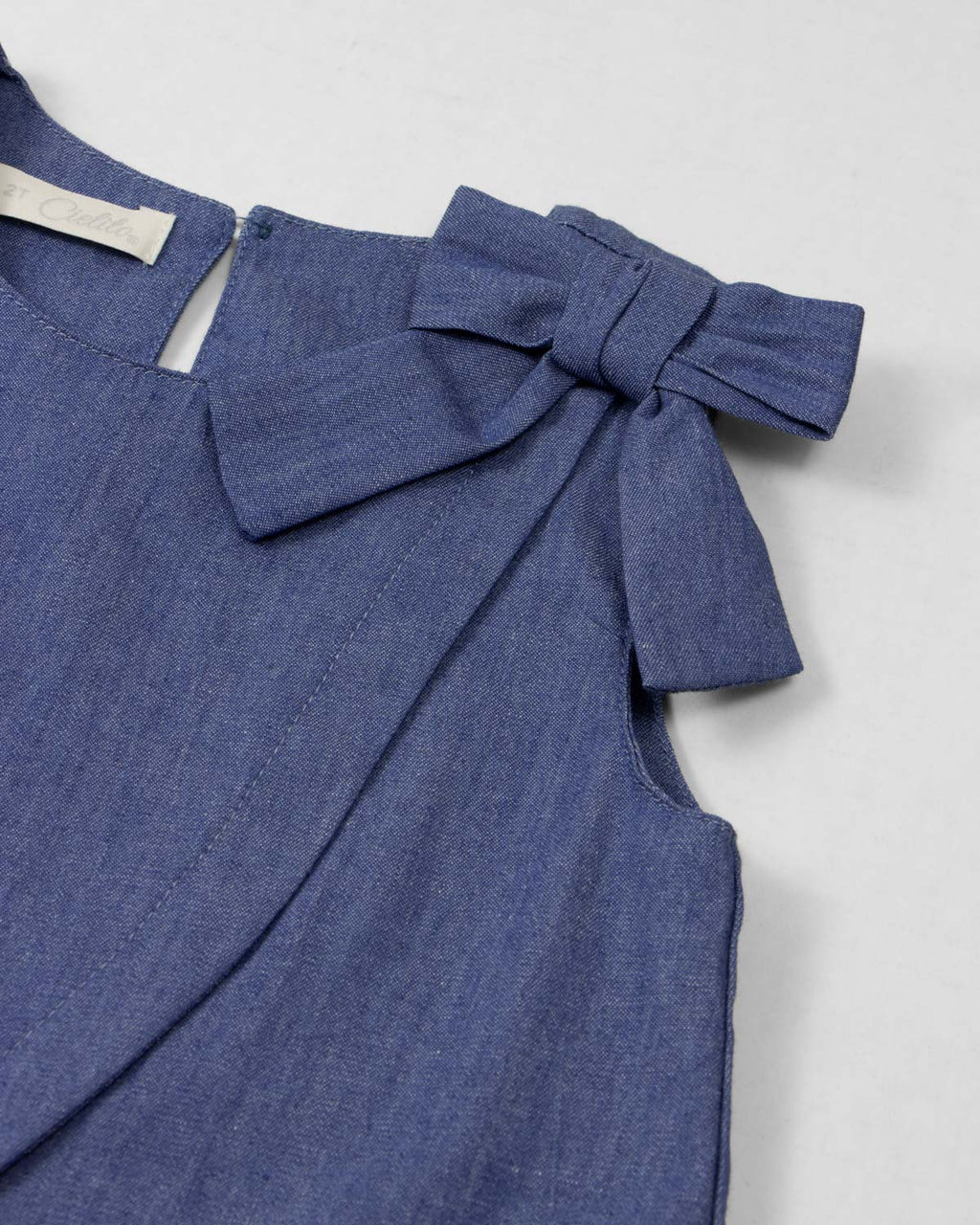 Conjunto blusa chambray con moño y falda short rosa con pliegues para niña